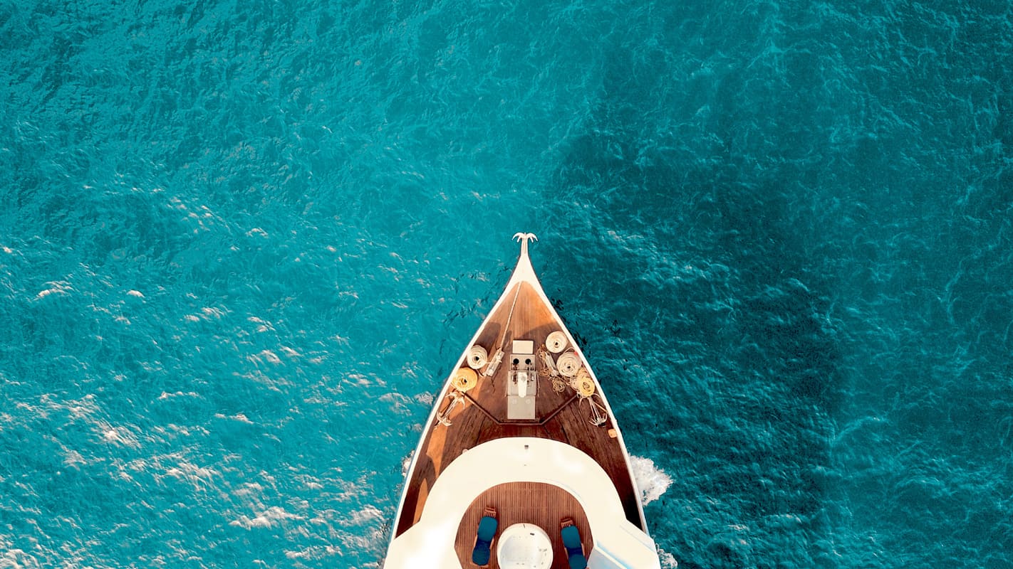 a yacht sails on clear blue sea
