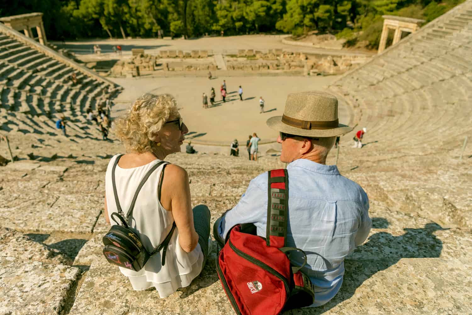 two tourists sit at the top of the classical Greek theatre dirong our private day tour from Athens